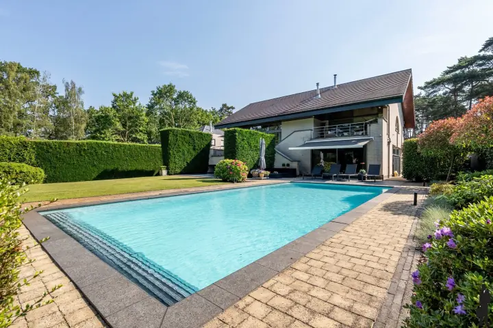 Verwarmd zwembad van 11 bij 5 meter met de villa op de achtergrond